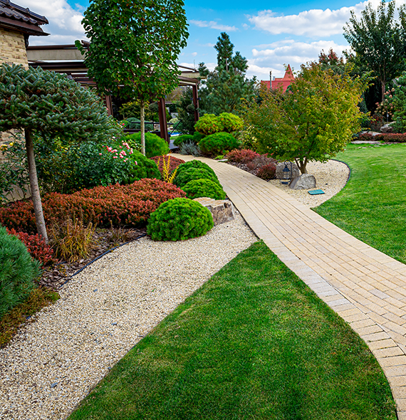 Front yard, landscape design with multicolored shrubs intersecting with bright green lawns behind the house is a modern, garden care service, green grass with a beautiful yard for the background.